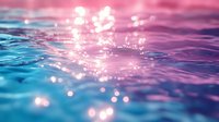 Shimmering water surface with pink and blue tones creating magical bokeh effect. Dreamy aquatic background with sunlight reflections and rippling waves. Suitable for wellness and spa designs.