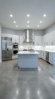 Modern white kitchen with marble backsplash, stainless steel appliances, center island and polished concrete floors in contemporary home interior.