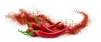 Fresh red chili peppers with explosive spice powder burst on white background. Hot cayenne pepper with paprika dust cloud for culinary design projects.