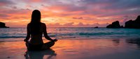 Woman silhouette meditating on beach at sunset with colorful sky reflection on wet sand. Peaceful yoga practice by ocean waves for wellness and mindfulness concepts.