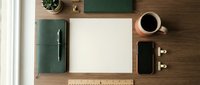 Organized workspace with blank notebook, coffee cup, smartphone and stationery on wooden desk. Modern office setup for productivity and planning.