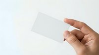 Male hand holding blank white card against neutral background, suitable for business branding, corporate identity mockups, and promotional material design.