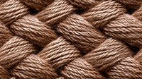 Woven brown natural rope in macro shot showing detailed texture and pattern of twisted fibers. Seamless repeating background for craft and nautical designs.