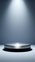 Metallic silver cylindrical podium platform with dramatic spotlight illumination on gradient blue background for product display and presentation.