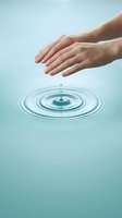 Hands of a Caucasian woman hovering above water surface with concentric ripples from a droplet, symbolizing purity, wellness, and environmental care for spa, healthcare, and sustainability concepts.