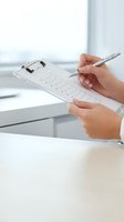 Professional hands filling out medical form on clipboard with pen in modern healthcare office environment for patient registration and documentation.