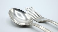 Vintage silver spoon and fork on white background, classic cutlery set with elegant metallic finish for food, dining, and kitchen concepts.