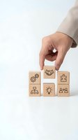 Business hand placing wooden cube with handshake icon among blocks showing teamwork, innovation and strategy symbols for corporate partnership concepts.