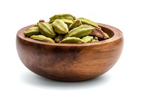 Green cardamom pods in wooden bowl isolated on white background. Aromatic whole spices for cooking Asian and Indian cuisine, natural food ingredient.