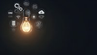 Glowing light bulb with technology icons and gears on dark background representing innovation, creativity and digital transformation concepts.