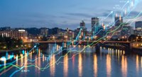 Financial growth chart overlay on city skyline at dusk with river reflections showing upward trending market data and economic prosperity indicators.