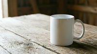 White ceramic coffee mug on rustic wooden table surface in warm natural lighting for morning beverage and kitchen lifestyle concepts.