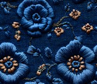 Embroidered blue flowers with golden centers on dark navy fabric create elegant floral pattern, showcasing intricate needlework detail and textile artistry.