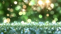 Magical green bokeh background with sparkling glitter and blurred light effects creates dreamy atmosphere for festive designs and holiday celebrations.