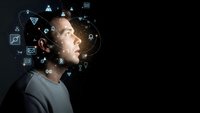 Young man surrounded by glowing digital icons and technology symbols on dark background representing artificial intelligence and innovation.
