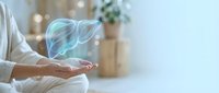 Holographic liver organ floating above open palm in modern medical office setting for healthcare technology and digital medicine concepts.