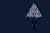 Businessman standing under abstract Christmas tree made of white paper airplanes on dark blue background, minimalist creative holiday concept.