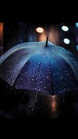 Blue umbrella with raindrops illuminated by street lights on dark rainy night, creating atmospheric mood with bokeh effects in background.
