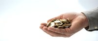 Business professional holding golden coins in cupped hands representing financial growth, investment opportunities and wealth management concepts.