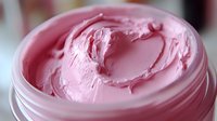 Pink creamy cosmetic product in open jar with smooth swirled texture for skincare beauty routine and spa treatments.