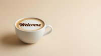 Creamy cappuccino in a white cup with Welcome written in latte art on a warm beige background, copy space for hospitality and cafe concepts.