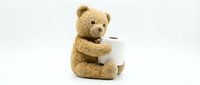 Adorable brown teddy bear holding white mug isolated on white background for children design projects and nursery decor.