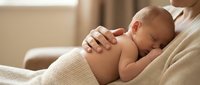 Newborn baby breastfeeding with mother in soft natural light creating intimate bonding moment for parenting and healthcare concepts.
