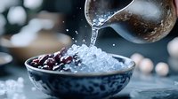 Pouring water over fresh berries in blue ceramic bowl creates dynamic splash and droplets against dark background with soft bokeh lights.