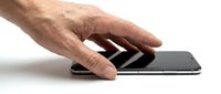 Male hand with light skin tone using touchscreen smartphone on white background for technology and communication concepts.