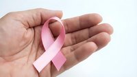 Pink ribbon symbol in open palm representing breast cancer awareness and support for survivors on white background.