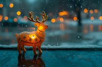 Glowing decorative reindeer figurine with ornate patterns standing in rain with bokeh lights creating magical holiday atmosphere on dark turquoise background.