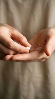 Cupped hands holding single white pill or medication tablet for healthcare and pharmaceutical concepts.
