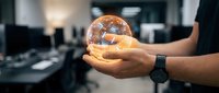 Hands holding glowing light bulb in modern office environment, representing innovation, ideas, energy efficiency, and sustainable business solutions for corporate design projects.