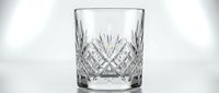 Crystal cut glass tumbler with diamond pattern etched design for whiskey bourbon scotch drinking isolated on white background for luxury bar decor.
