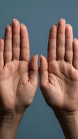 Two male hands raised with palms facing forward in stop gesture against blue background showing detailed skin texture and natural lighting.