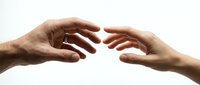 Two hands reaching toward each other with bright light between fingertips symbolizing connection, unity and human touch on white background.