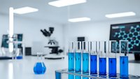 Modern laboratory with blue chemical solutions in test tubes and beakers for scientific research and analysis in sterile medical facility.