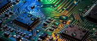 Close-up macro view of electronic circuit board with colorful LED lighting effects showcasing microchips, resistors and intricate pathways for technology designs.