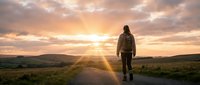 Woman jogging on rural road at golden hour sunrise or sunset, athletic runner exercising outdoors in countryside landscape with warm sky.