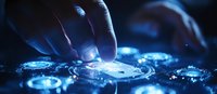Futuristic glowing blue circular interface with human hand interaction, featuring holographic technology elements and dynamic light effects in dark environment.