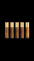 Five amber glass roller bottles with gold caps, isolated on transparent background. Ready for beauty, cosmetic, essential oil branding, stickers, print on demand, and t-shirt design use.