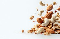 Mixed nuts scattered on white background with almonds, cashews and walnuts in dynamic composition with copy space for healthy snack concept.
