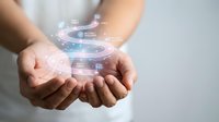Hands holding glowing digital holographic interface with data visualization and technology icons, representing innovation, connectivity, and future business solutions.