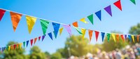 Colorful triangular bunting flags hanging outdoors against blue sky creating festive party atmosphere for celebrations and events.