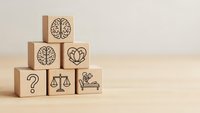 Wooden blocks with mental health symbols including brain, heart, scales of justice and question mark arranged on neutral background for wellness concepts.