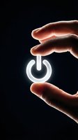 Hand holding glowing power button symbol against dark background, representing energy control, technology activation, and digital switch concept for business and innovation designs.