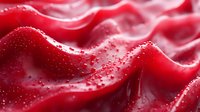 Red silk fabric with water droplets and wave texture, suitable for luxury fashion, textile design, and cosmetic product backgrounds.