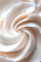 Swirled white meringue cream texture in macro shot showing soft peaks and delicate spiral pattern, suitable for food industry and confectionery advertising.