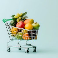 Fresh colorful fruits in miniature shopping cart on mint background, creative food market composition for healthy eating and grocery shopping concept.