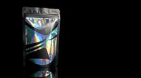 Holographic foil pouch packaging with iridescent rainbow reflections on black background for premium product branding and modern retail display.